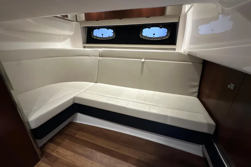 Slide: The Image of 2021 Chaparral 347 SSX cabin interior with white leather seating and wood flooring. - 55