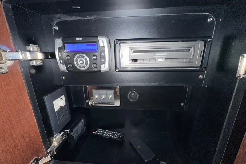 Slide: The Image of 2021 Chaparral 347 SSX audio system with control panel and remote inside cabinet. - 56