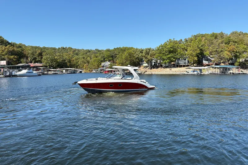 Slide: The Image of 2021 Chaparral 347 SSX boat cruising on a scenic lake with wooded shoreline. - 8