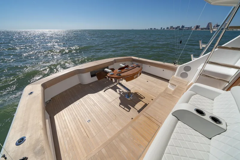Slide: The Image of 2023 Viking 64 Convertible yacht deck with ocean view and city skyline. - 19