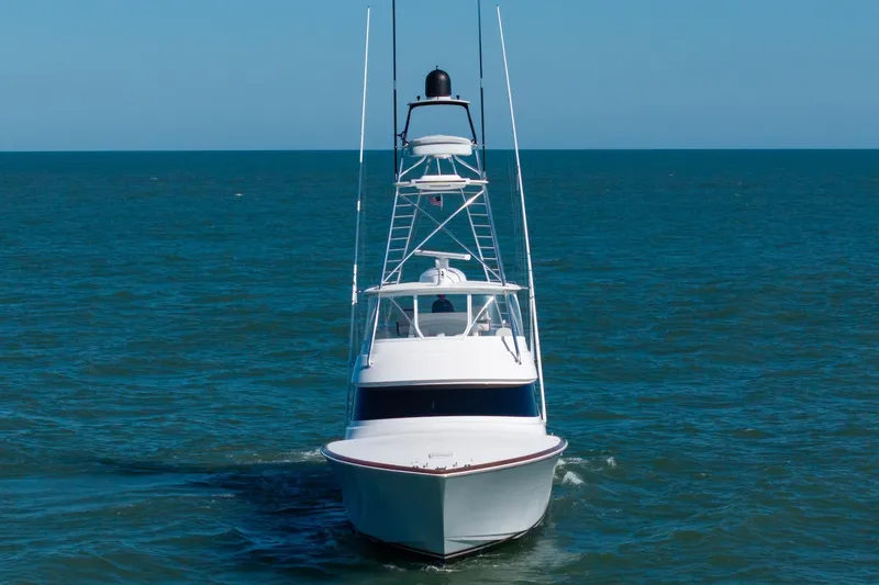 Slide: The Image of 2023 Viking 64 Convertible yacht cruising on open sea under clear blue sky. - 2