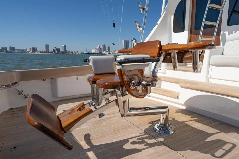 Slide: The Image of 2023 Viking 64 Convertible yacht deck with fishing chair, city skyline in background. - 20