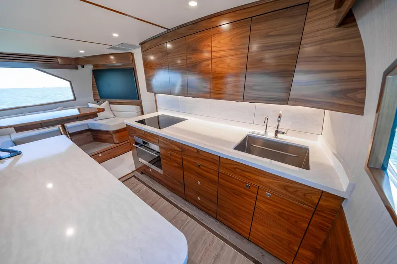 Slide: The Image of Luxurious kitchen interior of 2023 Viking 64 Convertible yacht with sleek wood cabinetry. - 26