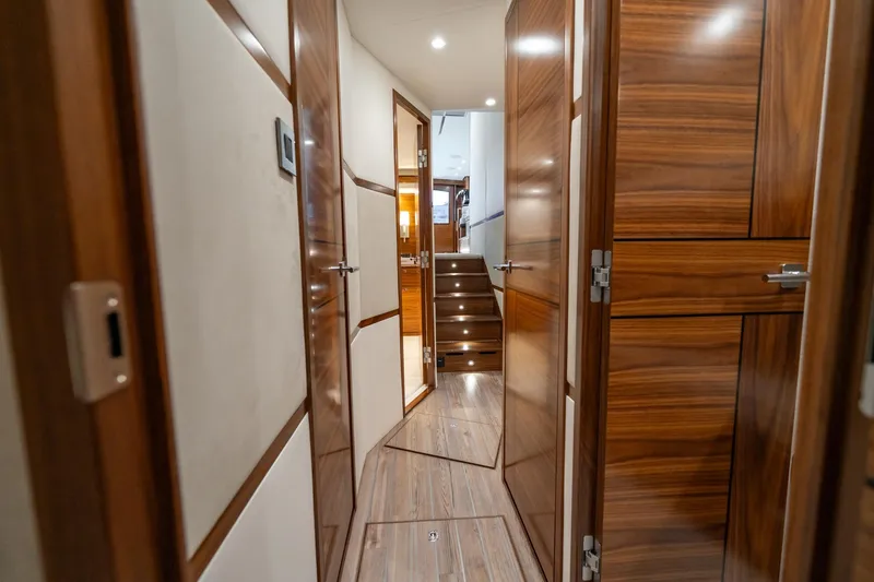 Slide: The Image of Interior hallway of 2025 Viking 64 Convertible yacht with wooden doors and stairs. - 29