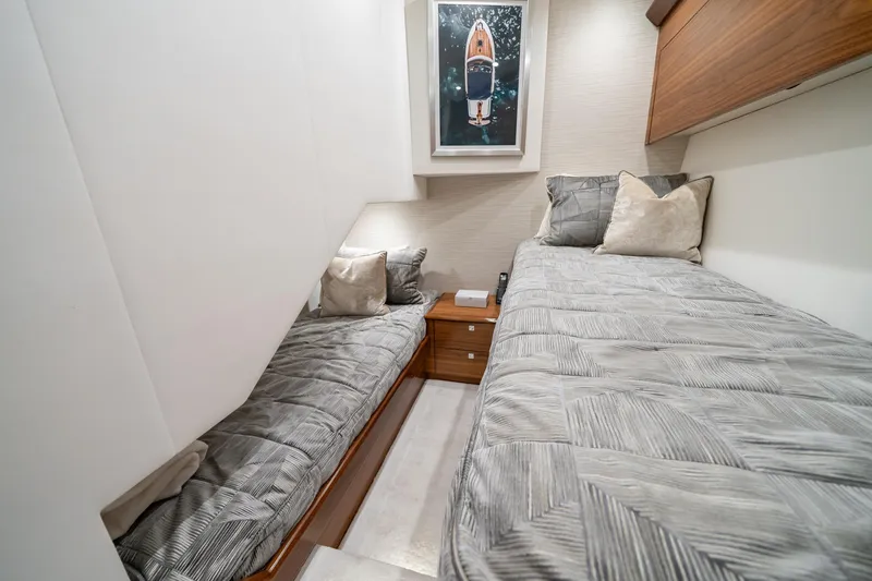 Slide: The Image of 2025 Viking 64 Convertible yacht cabin with twin beds and modern decor. - 36