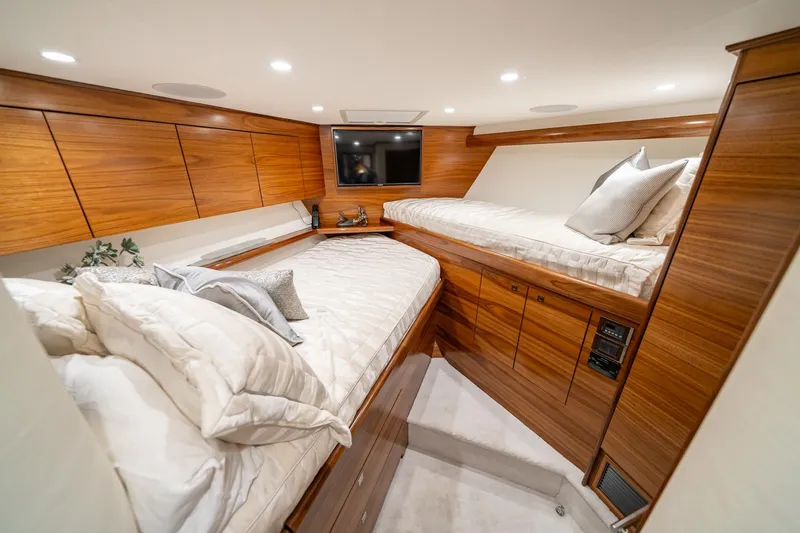 Slide: The Image of Luxurious cabin interior of 2025 Viking 64 Convertible yacht with wooden finishes and cozy bedding. - 39