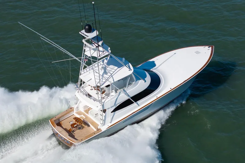 Slide: The Image of 2023 Viking 64 Convertible yacht cruising swiftly on open water. - 4