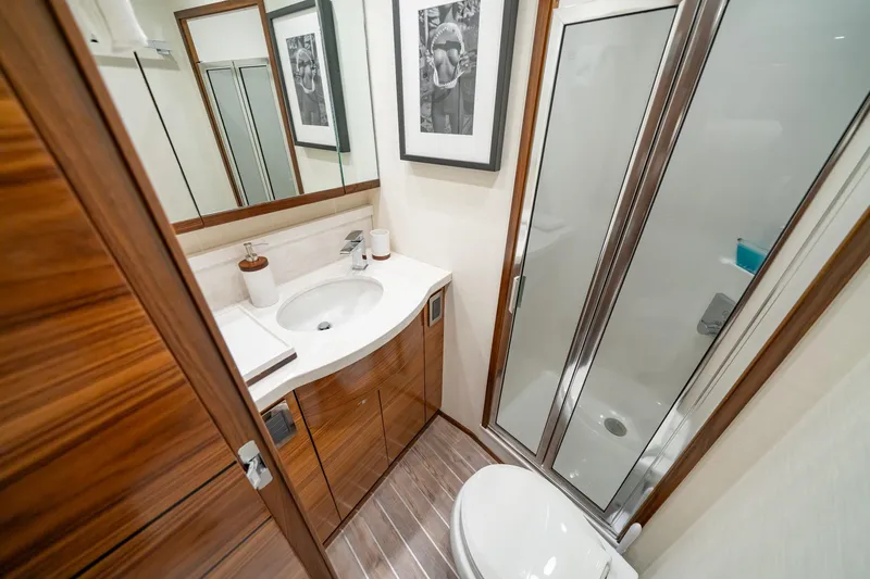 Slide: The Image of Luxurious bathroom in 2023 Viking 64 Convertible yacht with modern fixtures and elegant wood finishes. - 40