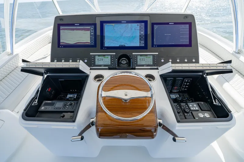 Slide: The Image of 2023 Viking 64 Convertible yacht helm with advanced navigation displays and controls. - 9