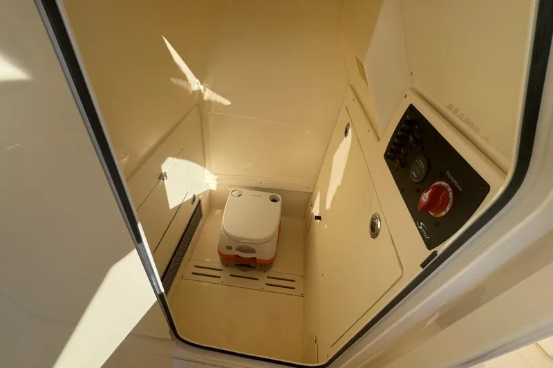 Slide: The Image of 2025 Scout 215 XSF boat interior with compact toilet and control panel. - 10