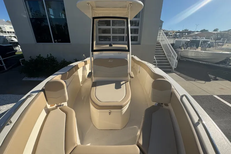 Slide: The Image of 2025 Scout 215 XSF boat interior with beige seating and center console. - 5
