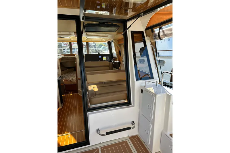 Slide: The Image of Interior view of 2020 Ranger Tugs R-29 boat, featuring seating and wood flooring. - 11