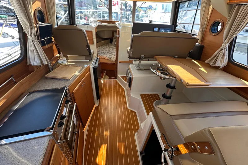 Slide: The Image of Interior of 2020 Ranger Tugs R-29 boat with wood accents and seating area. - 13