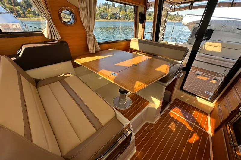 Slide: The Image of Interior of 2020 Ranger Tugs R-29 with wood accents and seating, overlooking water. - 15
