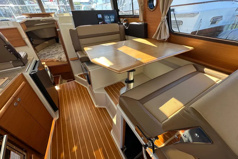 Slide: The Image of Interior of 2020 Ranger Tugs R-29 with wood flooring and dining area. - 16