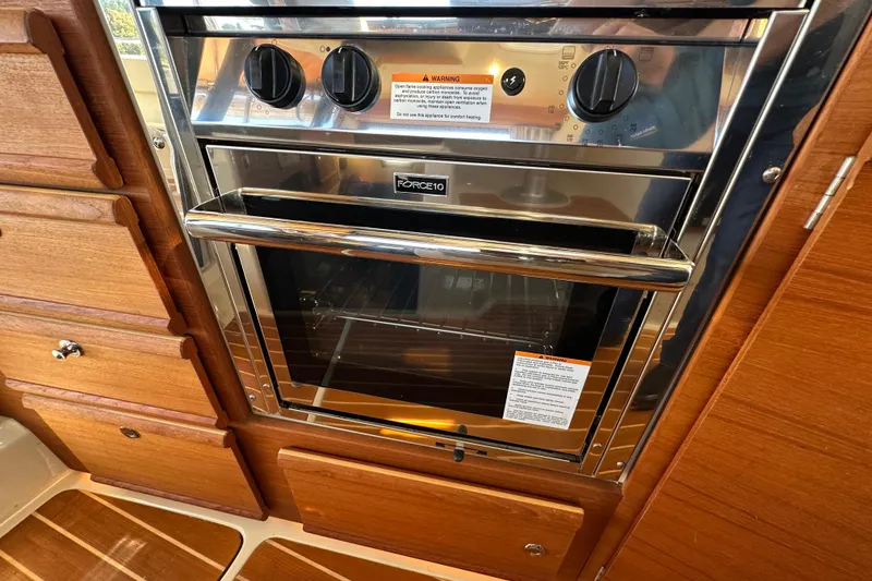Slide: The Image of Stainless steel oven in 2020 Ranger Tugs R-29 boat kitchen, surrounded by wooden cabinetry. - 22