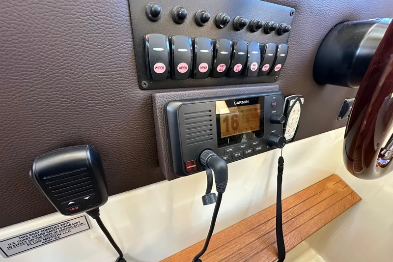 Slide: The Image of Control panel of 2020 Ranger Tugs R-29 with Garmin marine radio and switches. - 27