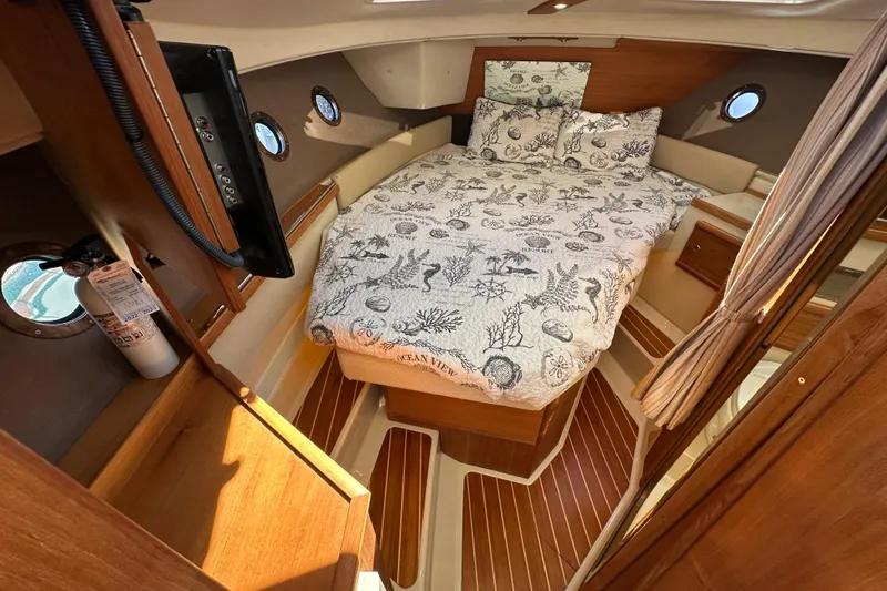 Slide: The Image of 2020 Ranger Tugs R-29 cabin interior with cozy bed and nautical decor. - 31