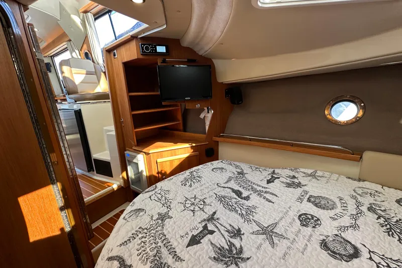Slide: The Image of Cozy interior of 2020 Ranger Tugs R-29 with bed, TV, and wooden cabinetry. - 33