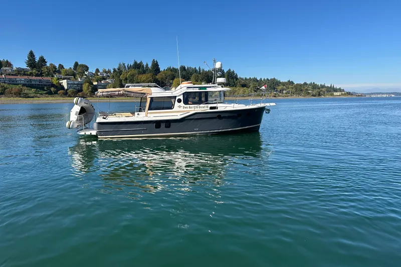 Slide: The Image of 2020 Ranger Tugs R-29 boat on calm water, scenic shoreline background. - 4