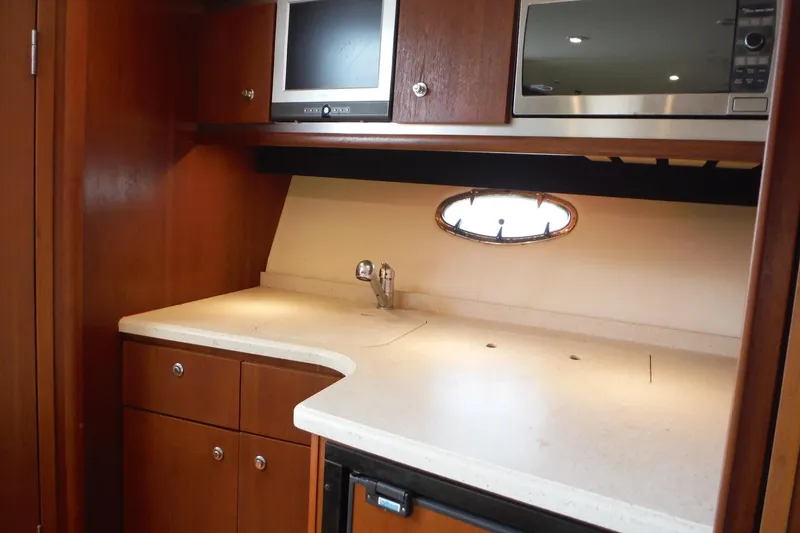 Slide: The Image of 2007 Tiara Yachts 3600 Open galley with wood cabinetry, countertop, and appliances. - 23
