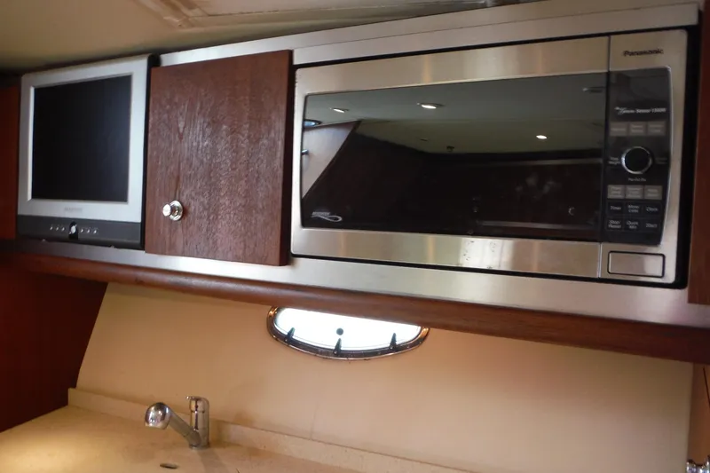 Slide: The Image of 2007 Tiara Yachts 3600 Open interior with microwave, TV, and wooden cabinetry. - 29