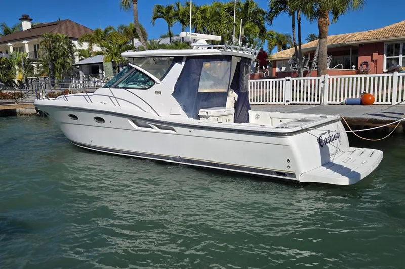 Slide: The Image of 2007 Tiara Yachts 3600 Open docked, surrounded by palm trees and waterfront homes. - 65