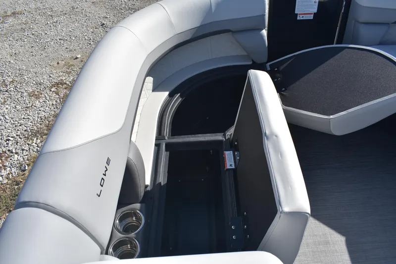 Slide: The Image of 2026 Lowe SS 230 WV boat interior with open storage compartment and cup holders. - 13
