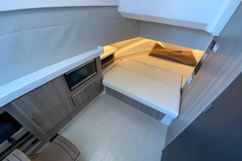 Slide: The Image of 2021 Regal 38 SAV interior cabin with modern design, featuring a cozy bed and microwave. - 25