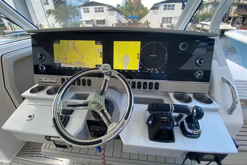 Slide: The Image of 2021 Regal 38 SAV boat helm with dual navigation screens and steering wheel. - 28