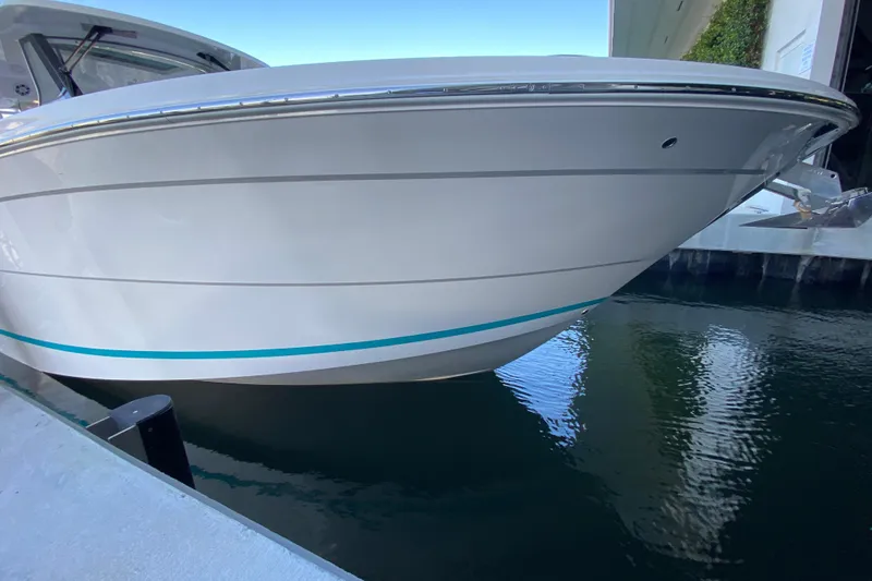 Slide: The Image of 2021 Regal 38 SAV boat docked, showcasing sleek white hull design. - 3