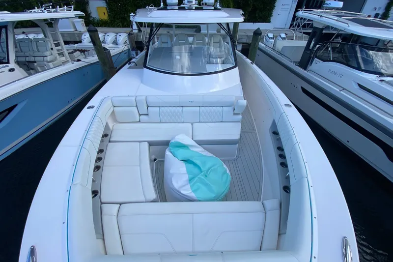 Slide: The Image of 2021 Regal 38 SAV luxury boat with spacious seating and sleek design at a marina. - 9