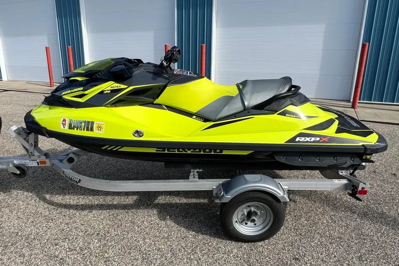 Slide: The Image of 2018 Sea-Doo RXP-X 300 jet ski in vibrant yellow on a trailer. - 11