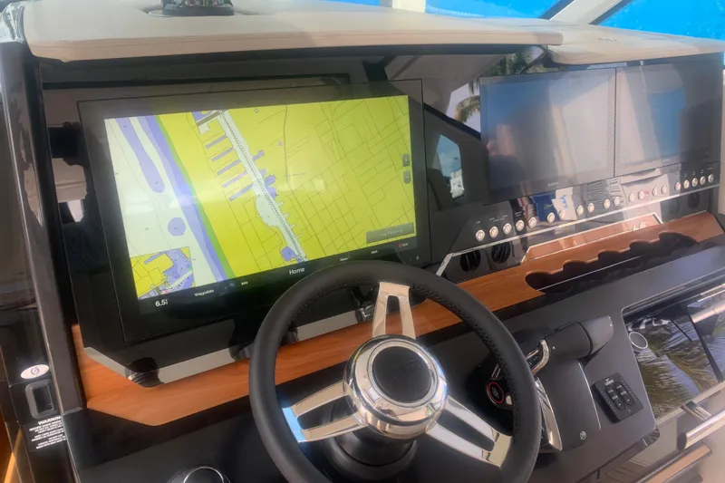 Slide: The Image of 2022 Tiara Yachts 48 LS helm with navigation screens and steering wheel. - 12