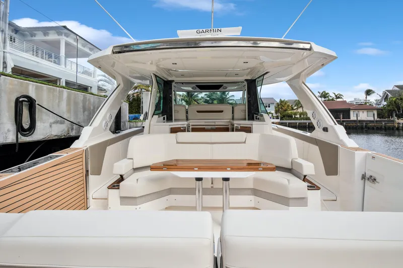 Slide: The Image of 2022 Tiara Yachts 48 LS luxury boat interior with seating and table, docked by waterfront homes. - 20