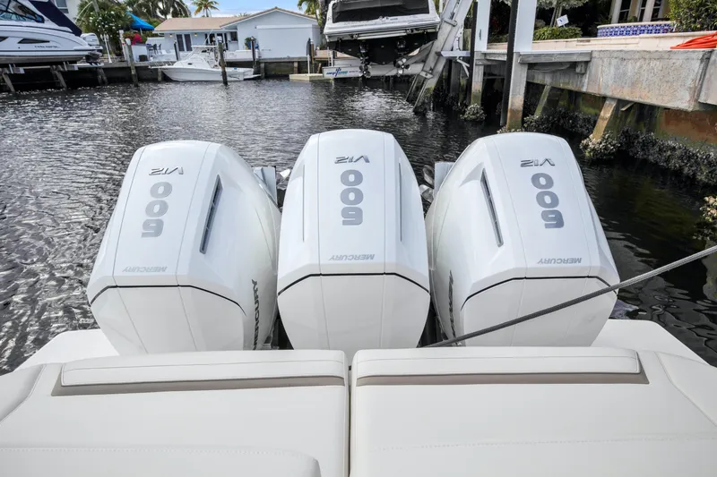 Slide: The Image of Triple Mercury 600 outboard engines on a 2022 Tiara Yachts 48 LS, docked in a marina. - 21