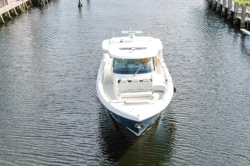 Slide: The Image of 2022 Tiara Yachts 48 LS cruising in a narrow waterway, front view. - 7