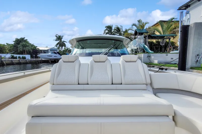 Slide: The Image of 2022 Tiara Yachts 48 LS luxury seating, docked by waterfront homes, under blue skies. - 8