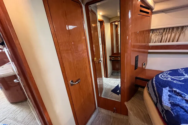 Slide: The Image of Interior of 2000 Sea Ray 460 Sundancer yacht with wood finishes and cozy bedroom. - 11