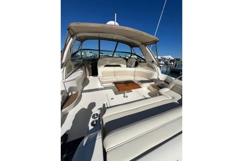 Slide: The Image of 2000 Sea Ray 460 Sundancer yacht interior with seating and table, docked under clear blue sky. - 3
