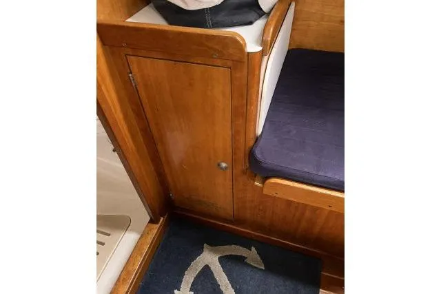 Slide: The Image of Interior of 2004 J Boats J/133 with wooden cabinet and navy cushion. - 10
