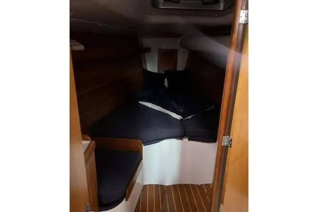 Slide: The Image of 2004 J Boats J/133 cabin interior with wooden finish and cozy bedding. - 13