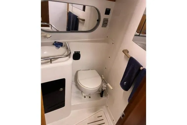 Slide: The Image of 2004 J Boats J/133 yacht bathroom with toilet, sink, mirror, and towel rack. - 18