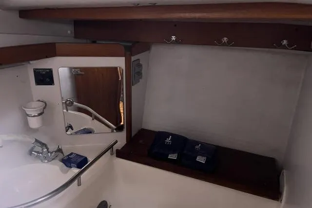 Slide: The Image of 2004 J Boats J/133 yacht interior with sink, mirror, and wooden shelving. - 21