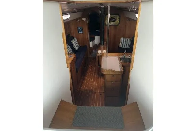 Slide: The Image of Interior of 2004 J Boats J/133 sailboat, featuring wood finish and compact galley. - 30
