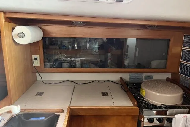 Slide: The Image of 2004 J Boats J/133 yacht kitchen with wooden cabinetry and stove. - 7