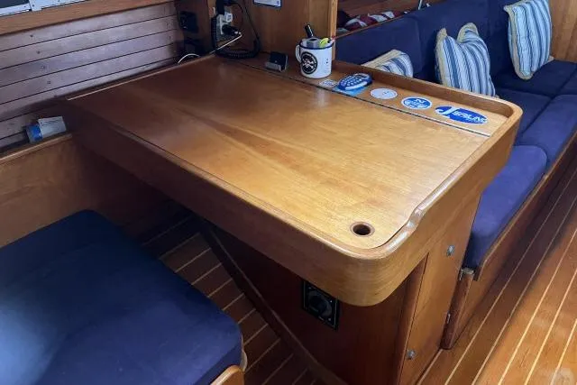 Slide: The Image of Interior of 2004 J Boats J/133 yacht with wooden table and blue seating. - 9