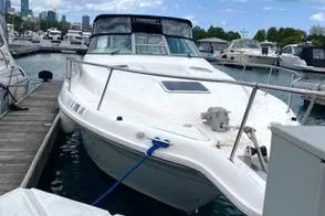 Slide: The Image of 1996 Sea Ray 330 Sundancer docked at marina with city skyline in background. - 4