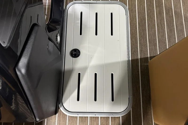 Slide: The Image of 2026 Premier 230 Sunsation RL boat deck with storage compartment and striped flooring. - 15