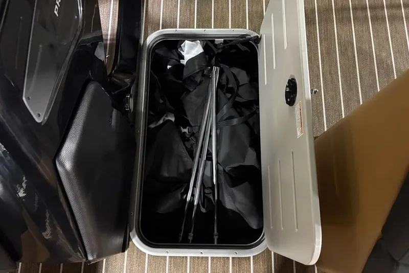 Slide: The Image of Open storage compartment in 2026 Premier 230 Sunsation RL boat, showing interior contents. - 16